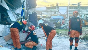 Equipes de resgate realizam uma operação de salvamento em um prédio que desabou