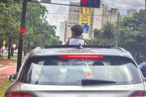 Foto: Motorista levou criança com o corpo para fora do teto solar do carro. (Fot