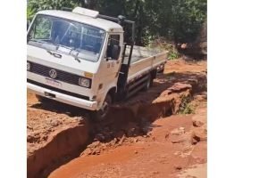 Caminhão impede que outros veículos passem em estrada com cratera. — Foto: Camin