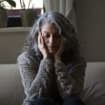 mulher-mais-velha-triste-no-sofa-scaled-1