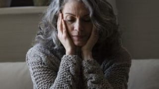 mulher-mais-velha-triste-no-sofa-scaled-1