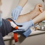Nurse taking blood sample from patient at the doctors office