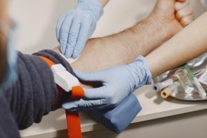 Nurse taking blood sample from patient at the doctors office