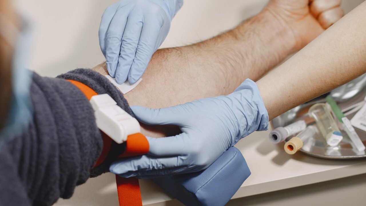 Nurse taking blood sample from patient at the doctors office