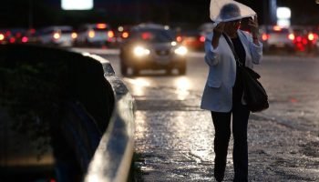 São Paulo (SP), 14/03/2023 - Pessoas se protegem da chuva no Viaduto Pompéia, em